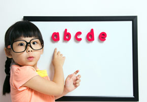 Asian girl at blackboard learning ABCs