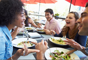 Group Of Friends Enjoying Meal At Outdoor Restaurant