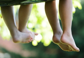 Happy children sitting on green grass outdoors in summer park