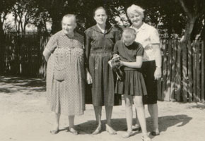 Vintage photo of two grandmothers, mother and daughter with a chicken