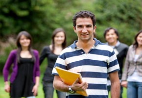 A male college student in the foreground with other college student s behind him