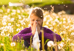 Girl sitting in a meadow with allergy