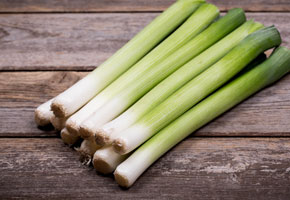 Baby leeks on old wood background