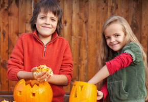 Kids carving their pumpkin jack-o-lanterns - removing the seeds