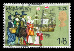 a postage stamp with pilgrims looking at the Mayflower