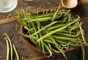 fresh green beans n a wooden bowl on a wooden table