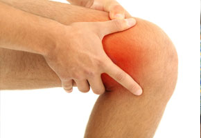 man holding his red swollen painful knee. sports injury