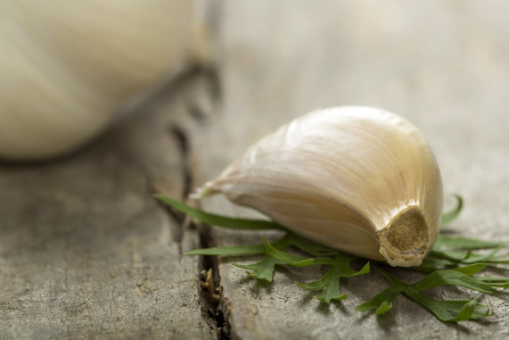 Garlic bulb and cloves over wood background